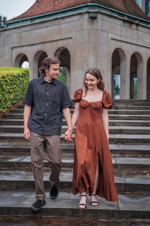 couple holding hands and walking down stairs at oakes garden theatre