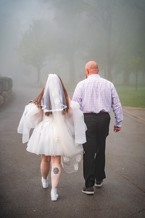 bride and groom walking in fog