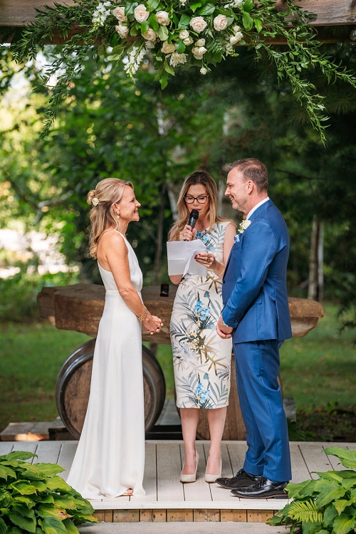  bride and groom smiling during ceremony