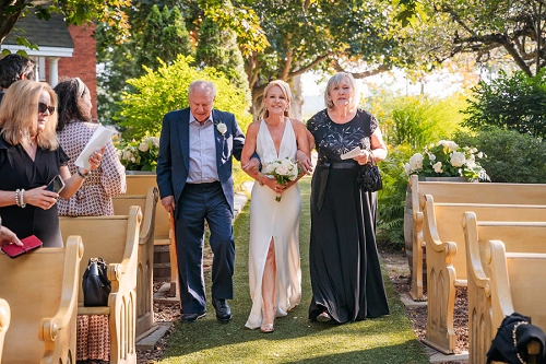  bride walking down aisle with parents