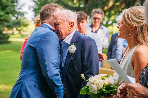 brides father and groom hugging