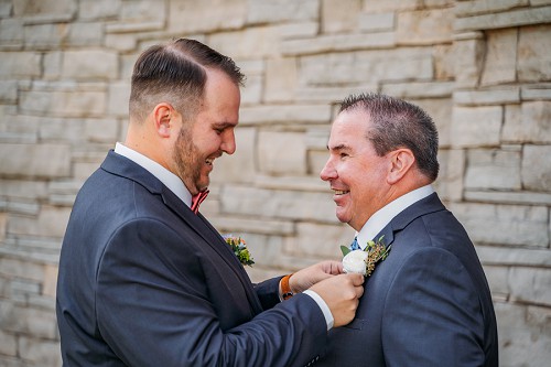 groom pinning flower on dad