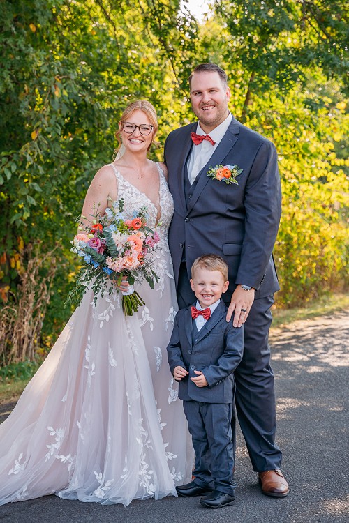 bride and groom with their son smiling