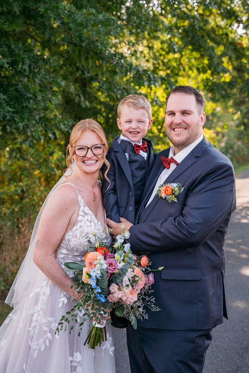 bride and groom holding their son