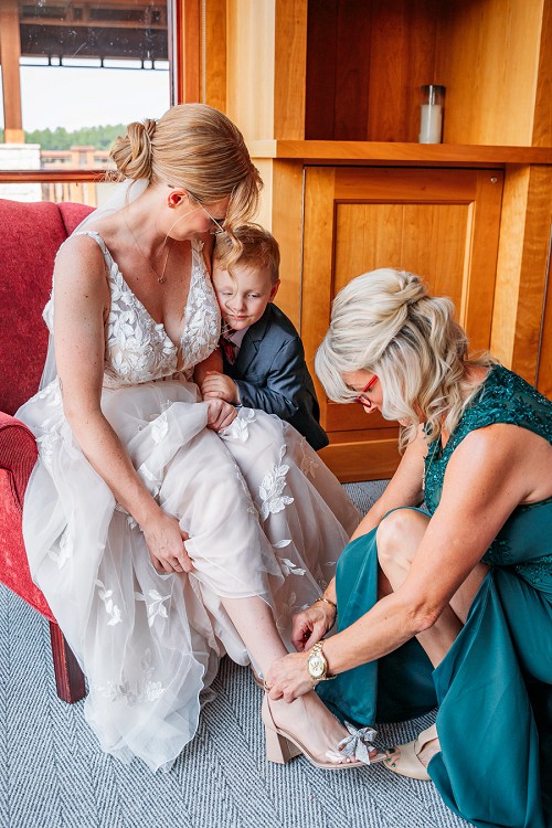 bride and mom putting on shoes