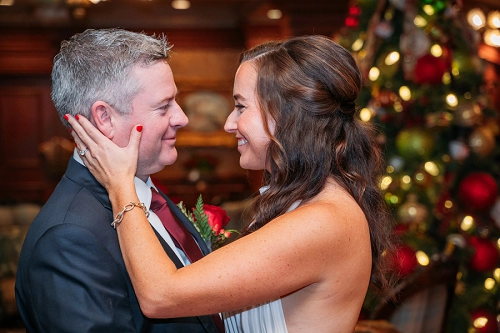 bride and groom with christmas tree in background 