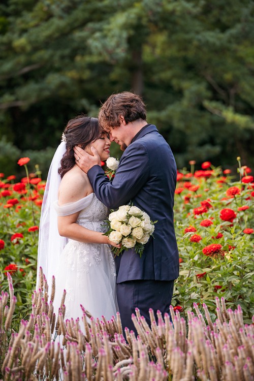 bride and groom in rose garden at botanical gardens