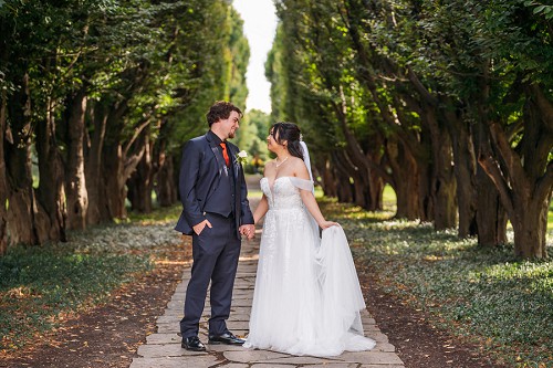 bride and groom at row of trees at niagara falls botanical garden