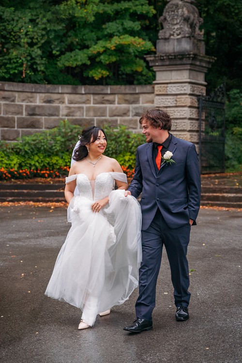 bride and groom laughing and walking in rain