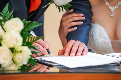 groom signing wedding license