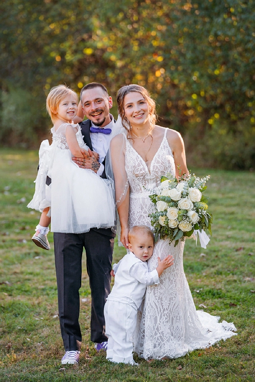 family portrait of bride, groom and their kids 