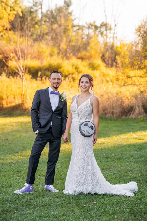 bride and groom holding hands with nightmare before christmas purse 