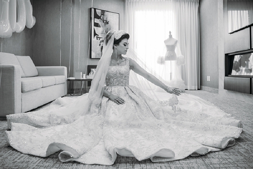  bride sitting and playing with her dress