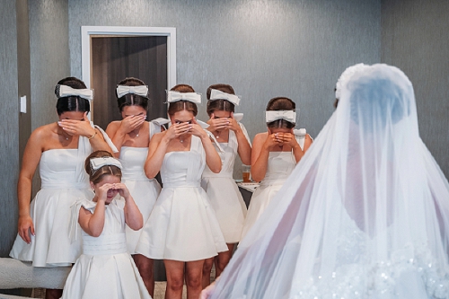 bridemaids with eyes closed for first look 