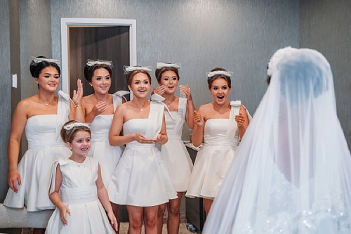  bridesmaids smiling while seeing bride for first time