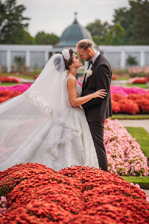  bride and groom kissing in rose garden at niagara botanical gardens